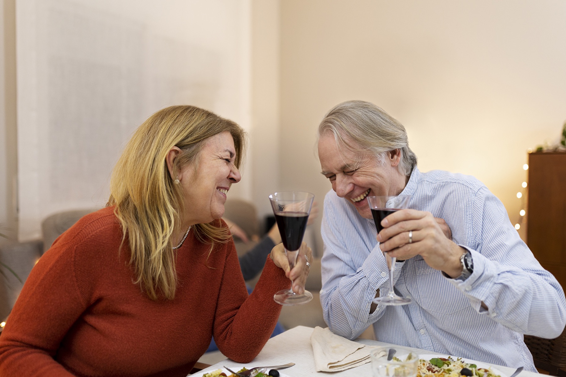 Older couple laughing together over dinner